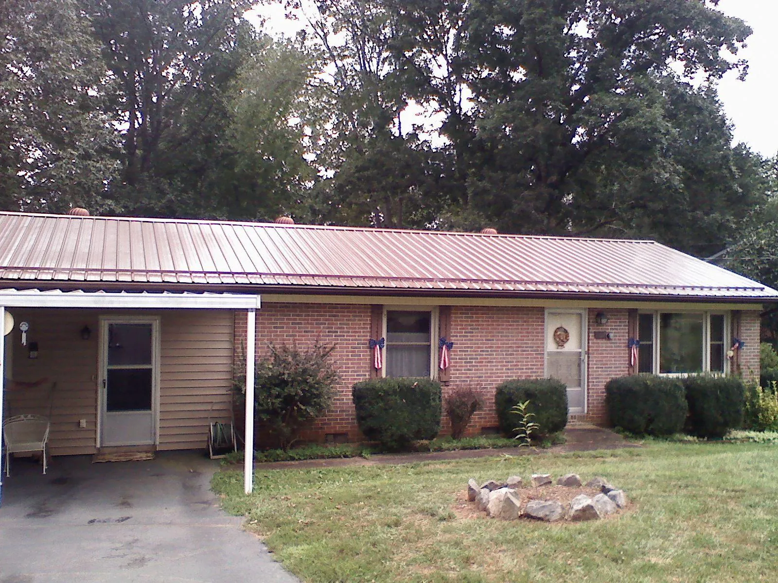 Bronze metal roof and carport on a brick ranch home — Roof Repair work by our crew in Toronto