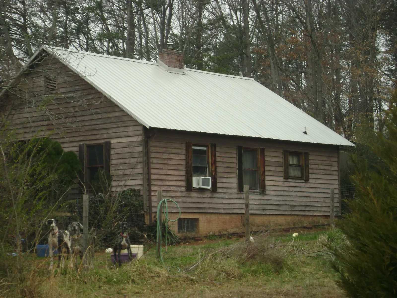 White metal roof on an old wood sided farmhouse, from a Metal Roof Installation job in Toronto